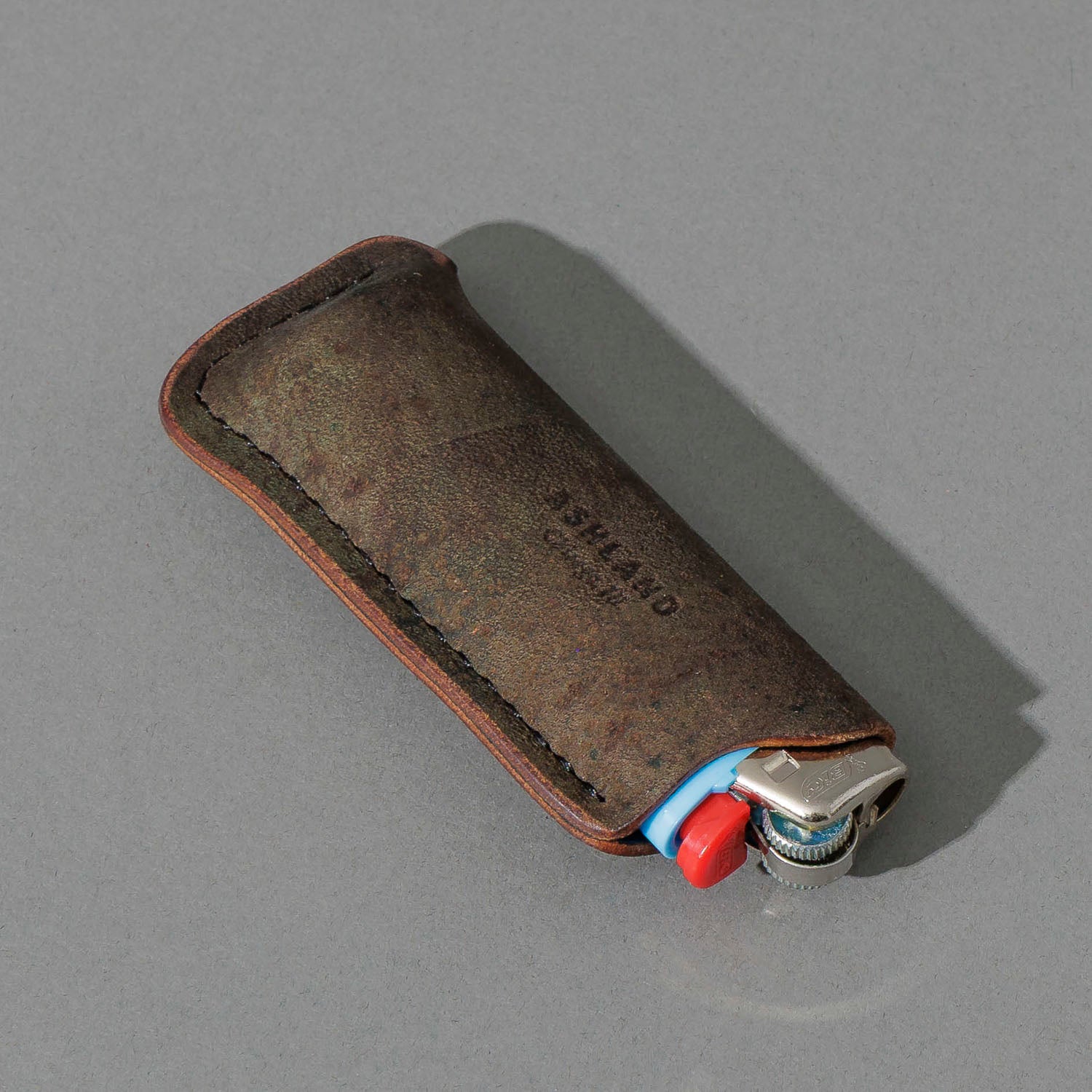 One-Off BIC Lighter and Sheath in Reverse Shell Cordovan, angled view lying flat