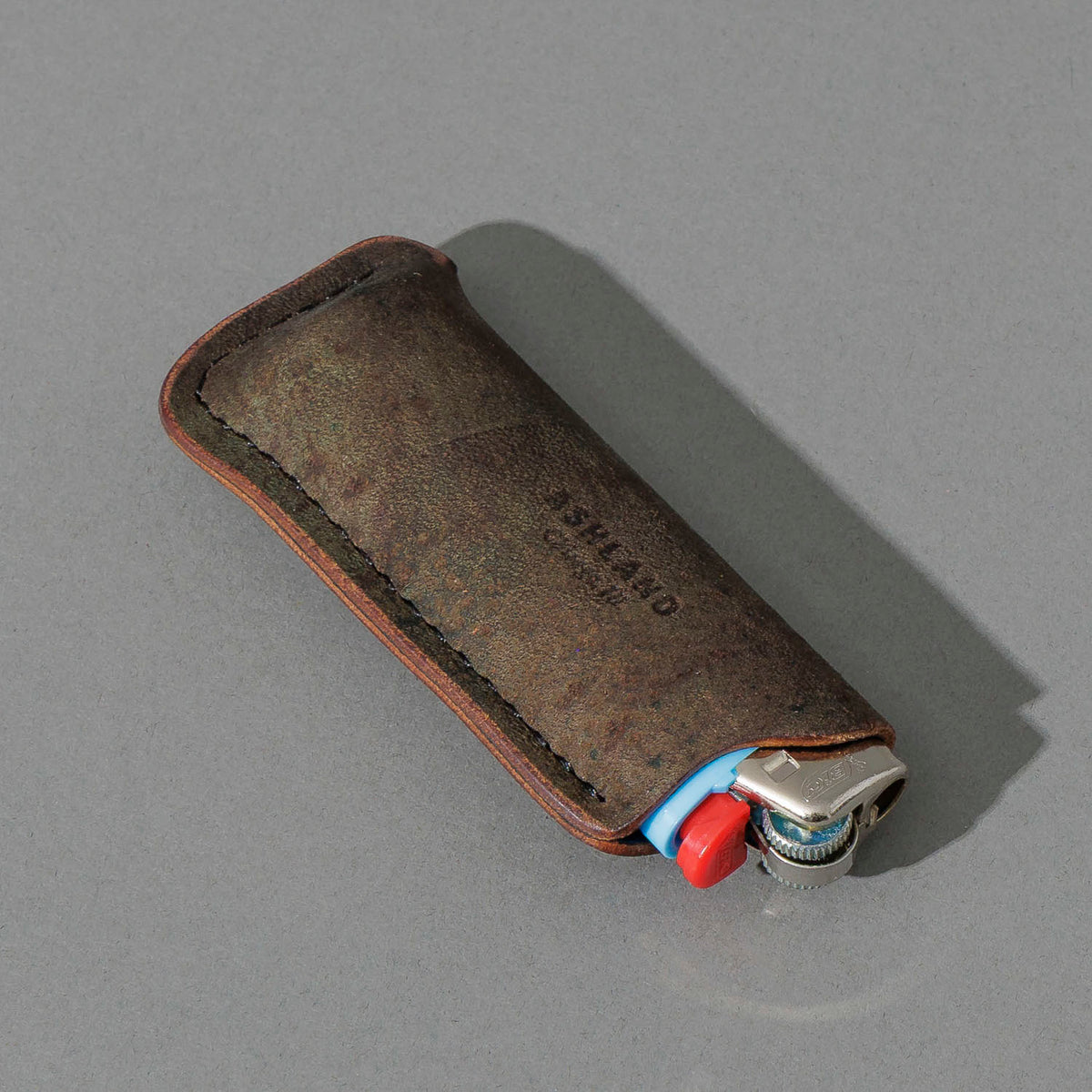One-Off BIC Lighter and Sheath in Reverse Shell Cordovan, angled view lying flat