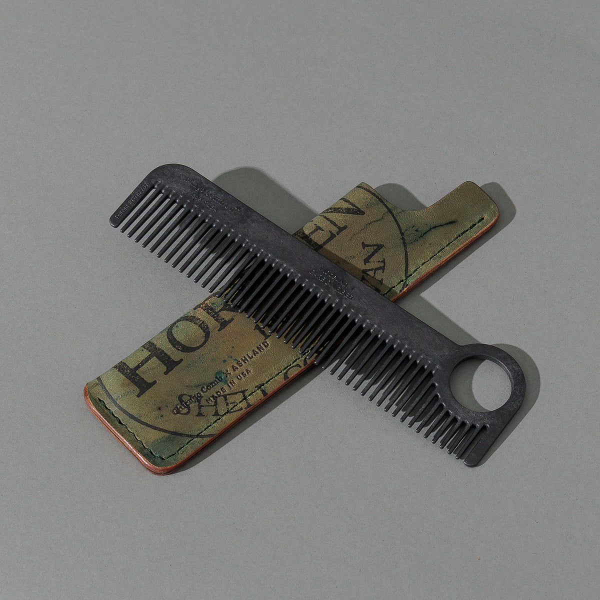 Chicago Comb and Leather Sheath in Reverse Shell Cordovan, with a black Chicago Comb crossed over the sheath