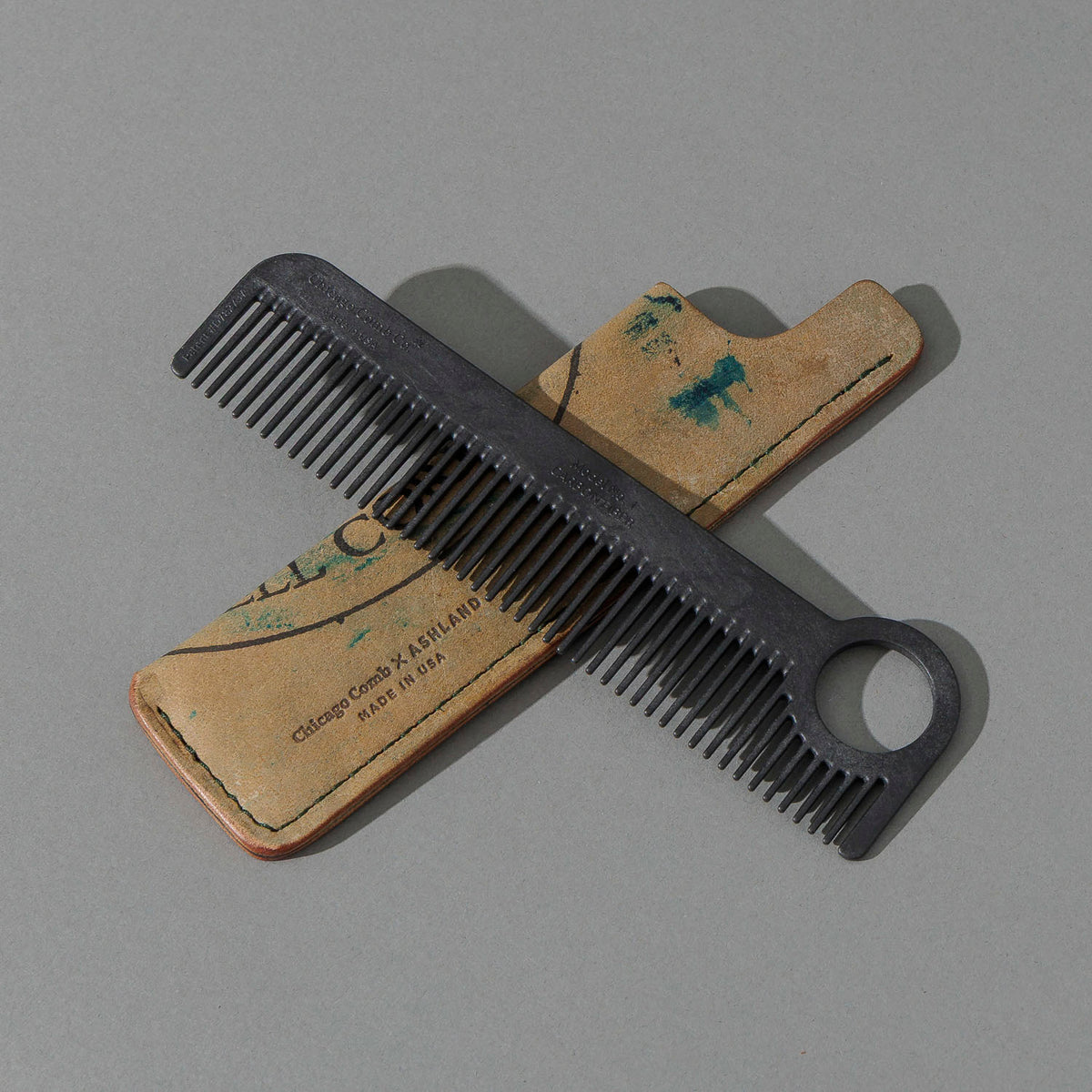 Chicago Comb and Leather Sheath in Reverse Green Shell Cordovan, with a black Chicago Comb crossed over the sheath