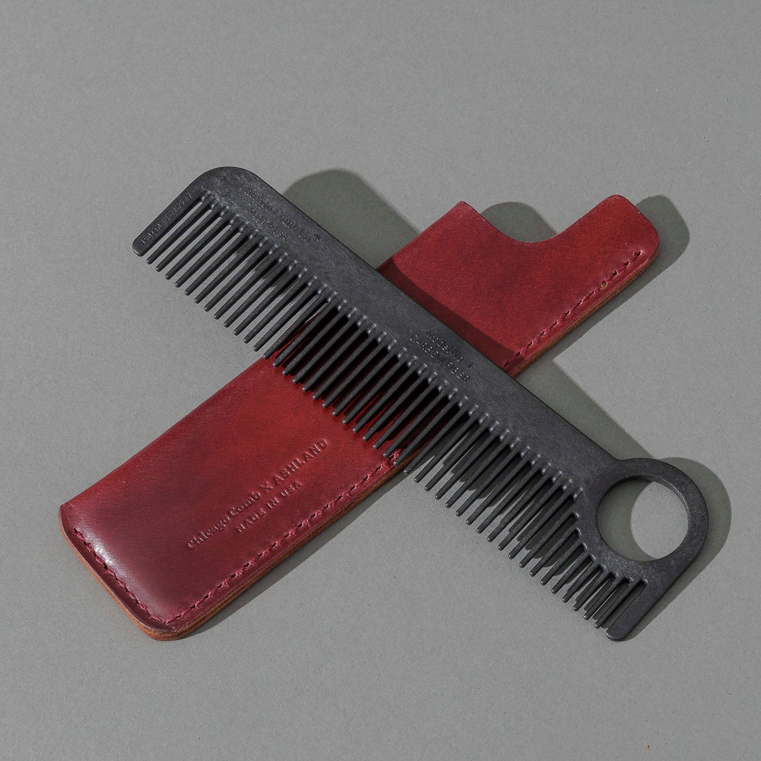 Chicago Comb and Leather Sheath in Marbled Ultraviolet Shell Cordovan, with a black Chicago Comb crossed over the sheath