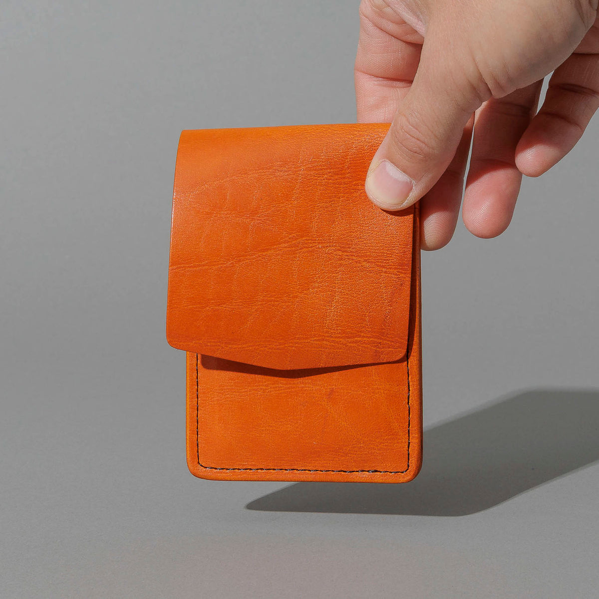 One-Off Lucky Wallet in Epic Orange Latigo, held in hand, shot 3