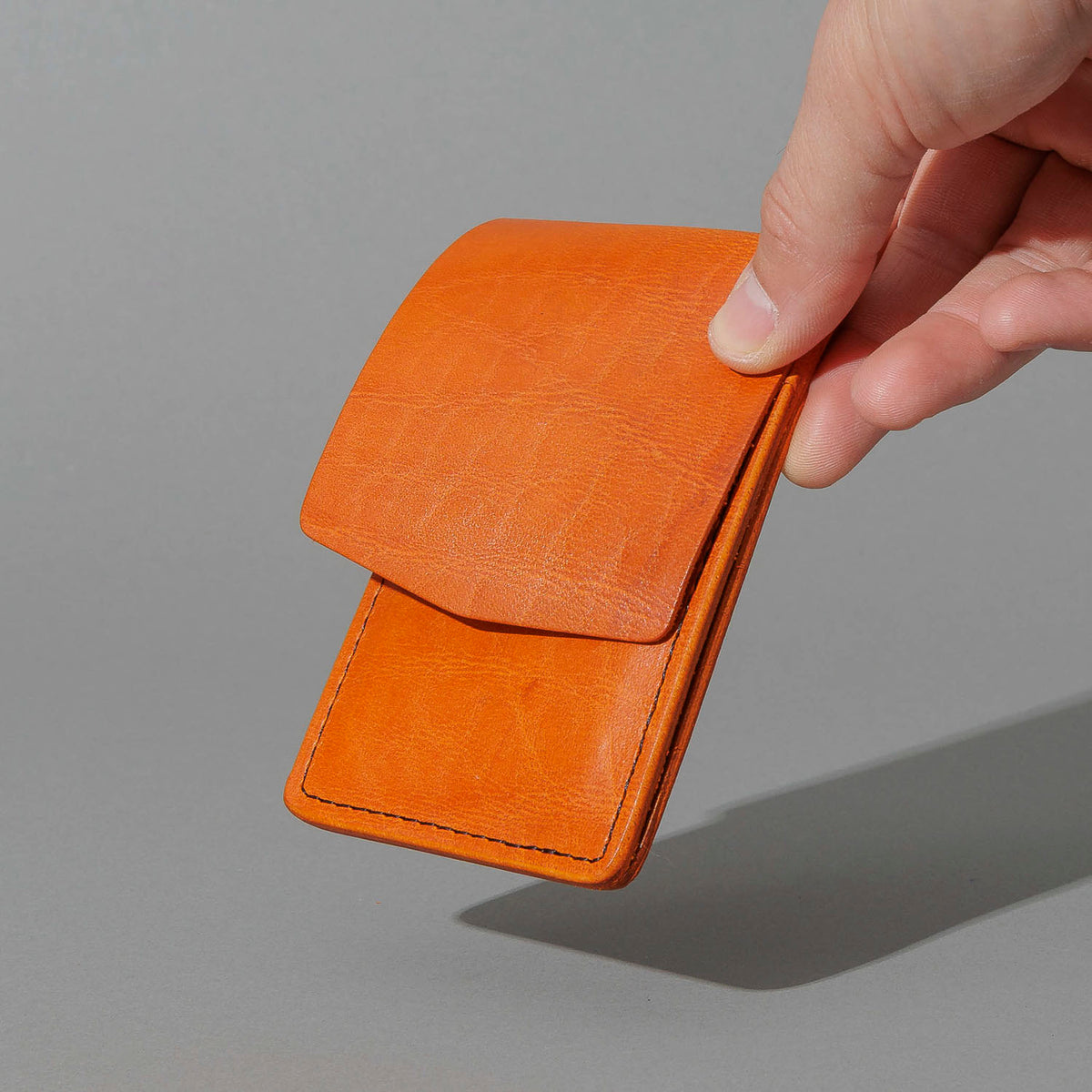 One-Off Lucky Wallet in Epic Orange Latigo, held in hand, shot 1