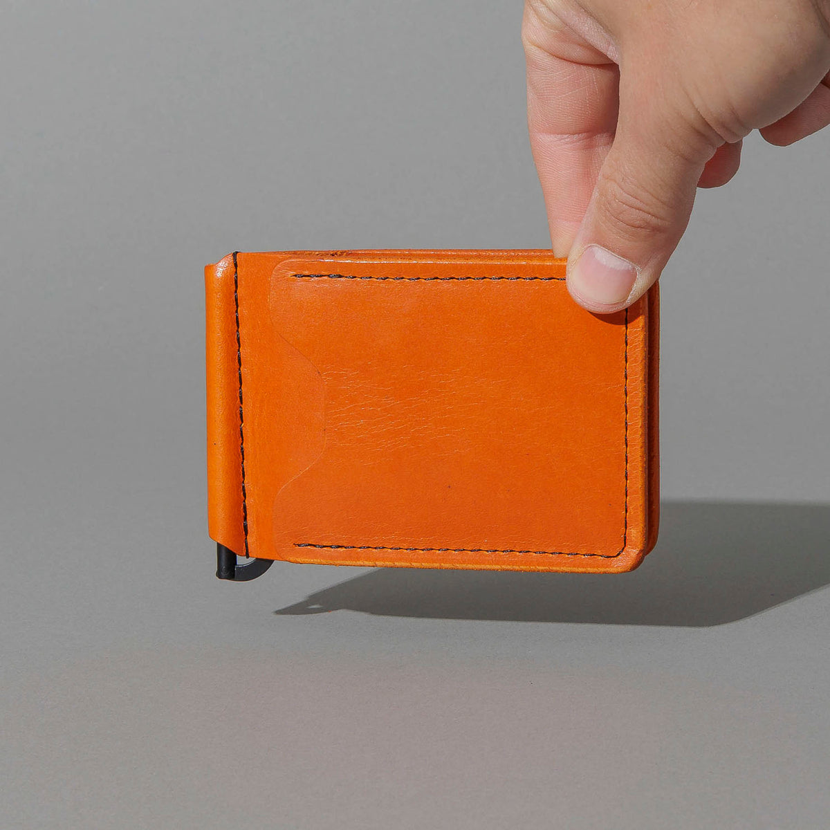 Capone Money Clip in Orange Latigo, held in hand, shot 2
