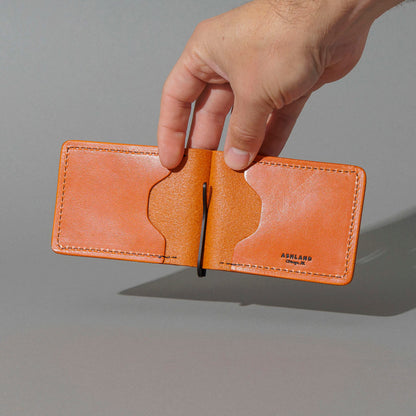 Capone Money Clip in Orange Latigo, held open in hand