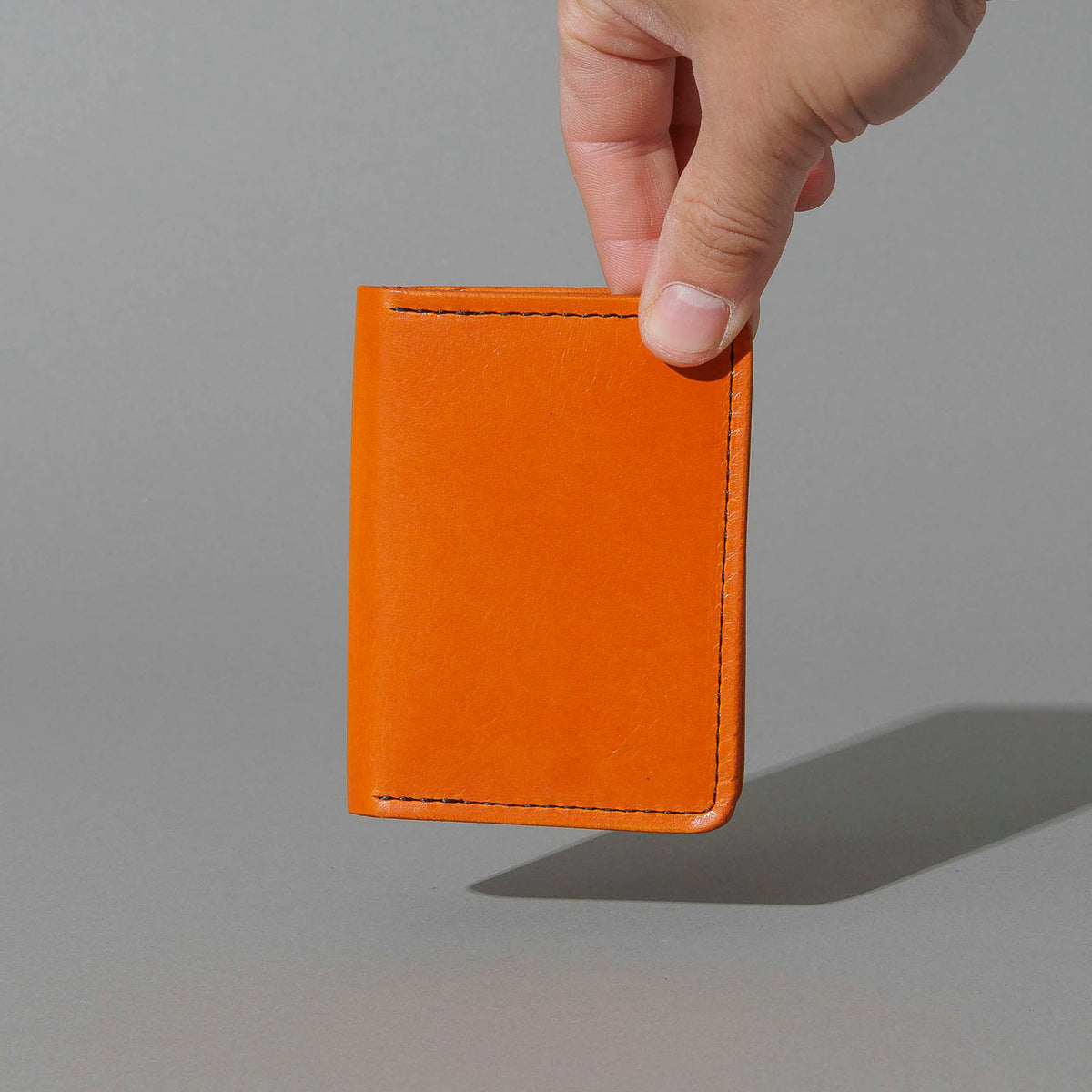 One-Off Six-Slot Bugs Moran Prototype in Orange Latigo, No Skip Stitch, held in hand, shot 1