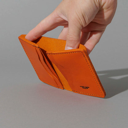 One-Off Six-Slot Bugs Moran Prototype in Orange Latigo, Skip Stitch, held open in hand, shot 1