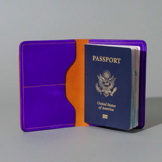Traveler Passport Holder in Orange Latigo Exterior, Violet Latigo Interior, open with a passport inside, shot 1