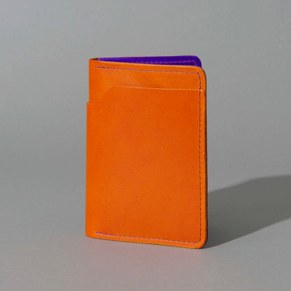 Traveler Passport Holder in Orange Latigo Exterior, Violet Latigo Interior, standing upright, side angle, shot 1