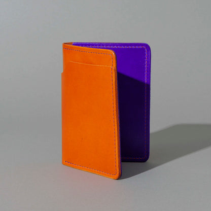Traveler Passport Holder in Orange Latigo Exterior, Violet Latigo Interior, standing upright, side angle, shot 2