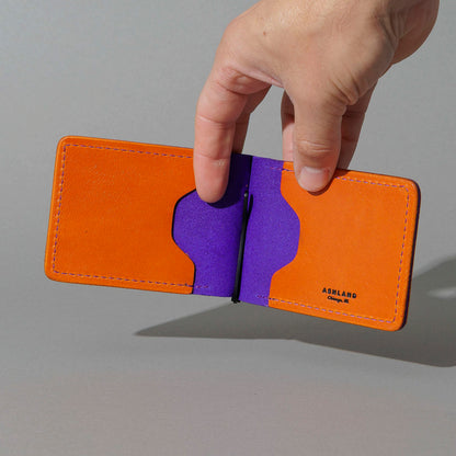 One-Off Capone Money Clip in Orange on Violet Latigo, held open in hand