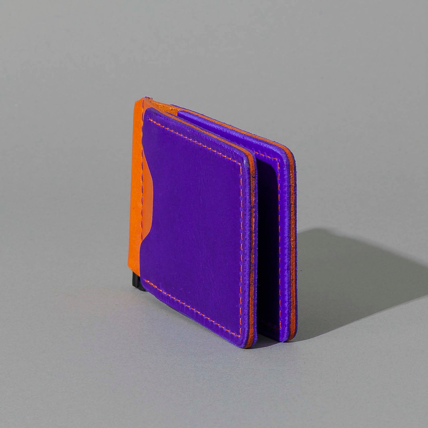 One-Off Capone Money Clip in Violet on Orange Latigo, standing upright, side angle