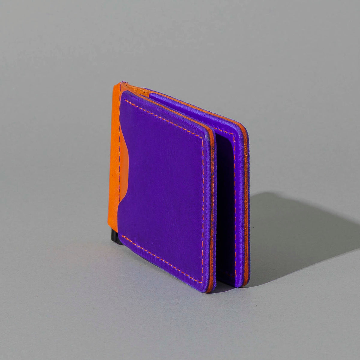 One-Off Capone Money Clip in Violet on Orange Latigo, standing upright, side angle