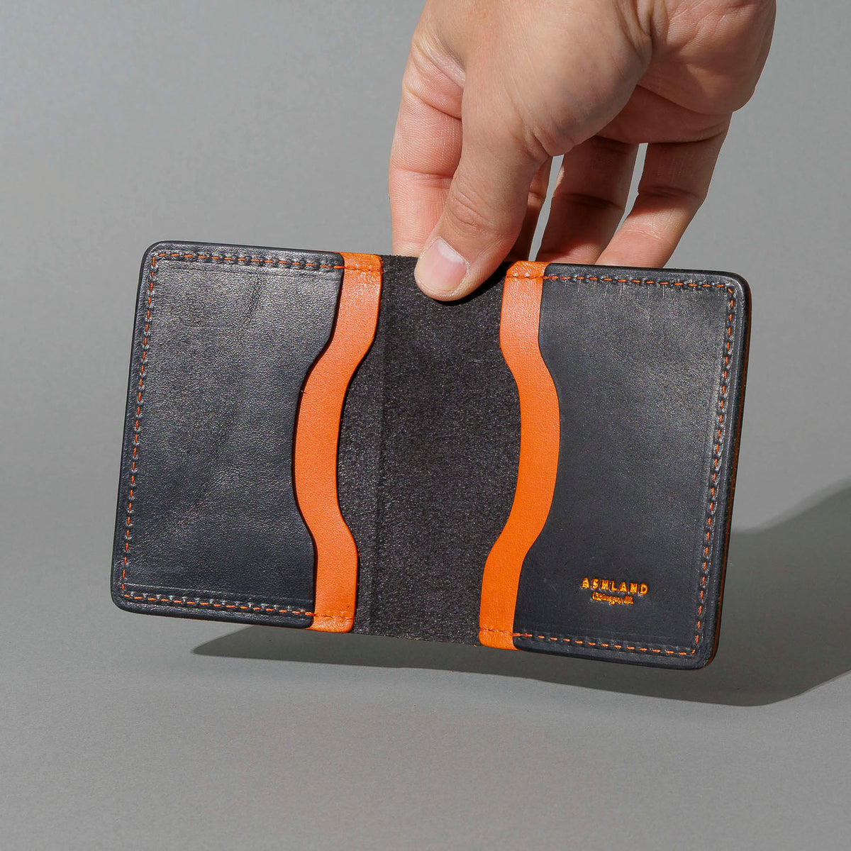 Tony the Ant in Black Dublin with Orange Accents, held open in hand, shot 2