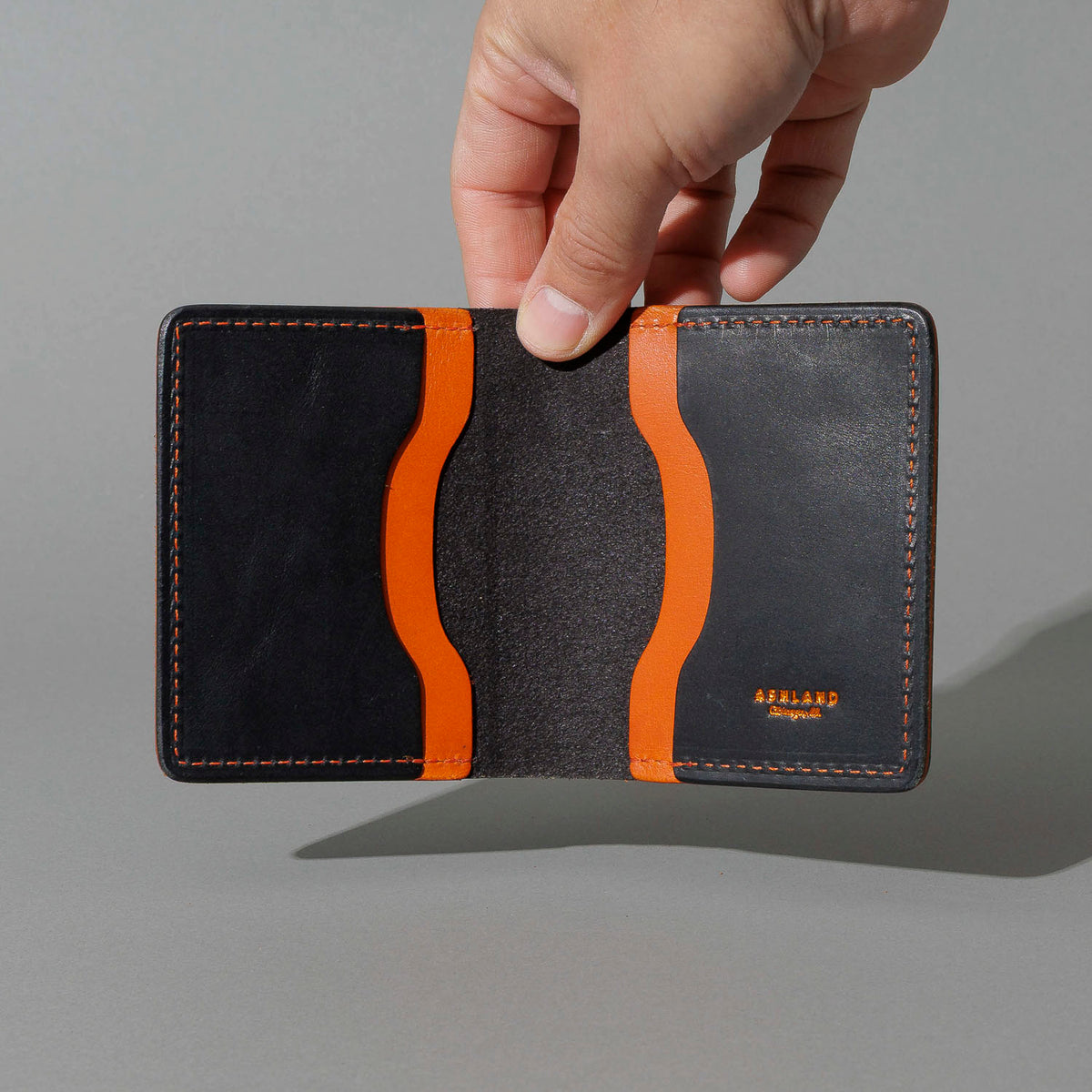 Tony the Ant in Black Dublin with Orange Accents, held open in hand, shot 3