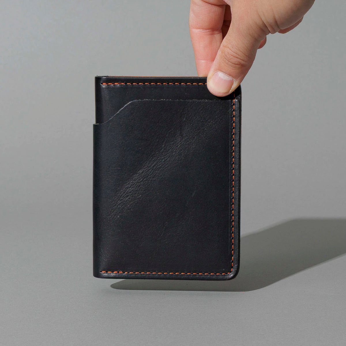 One-Off Fat Herbie in Black Dublin with Orange Accents, Two Hidden Card Slots, held in hand, shot 1