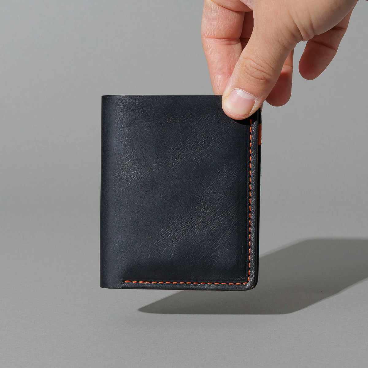 Tall Vertical Tony in Black Dublin with Orange Accents, held in hand, shot 1