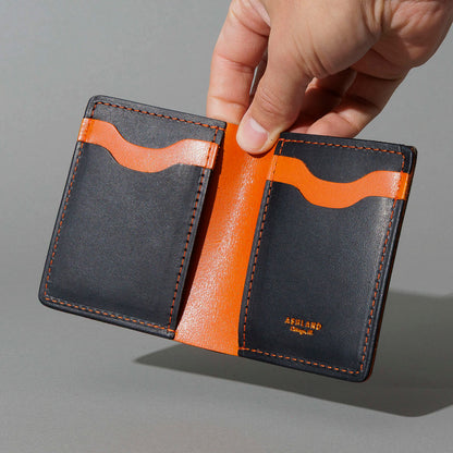 Tall Vertical Tony in Black Dublin with Orange Accents, held open in hand, shot 1