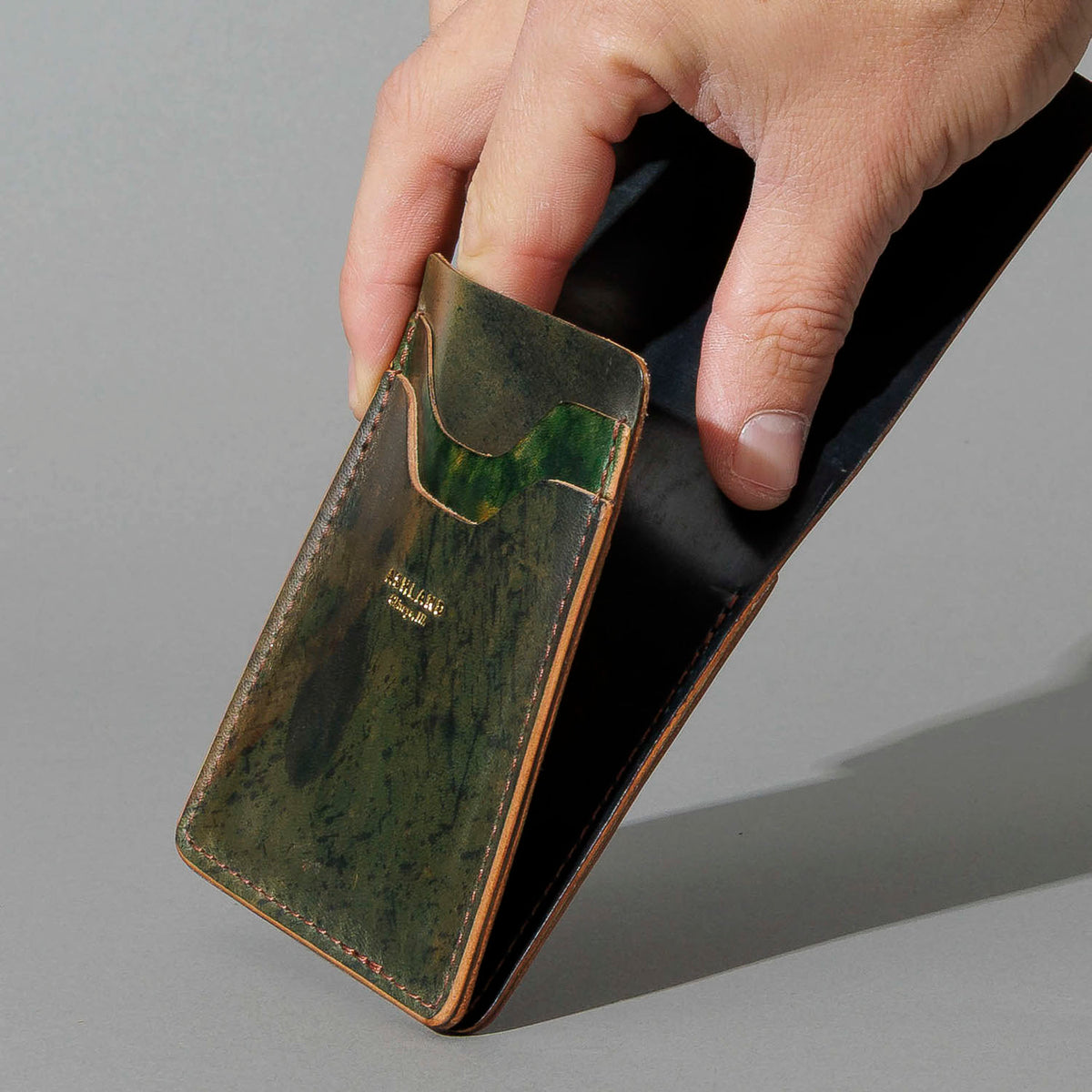 One-Off Lucky Wallet in Hand-Glazed Reverse Green Shell Cordovan, held in hand, shot 2