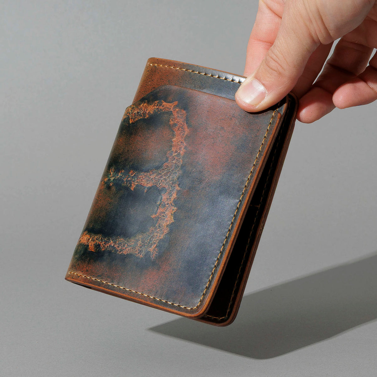 One-Off Fat Herbie in Branded Marbled Black Shell Cordovan, held open in hand, shot 2