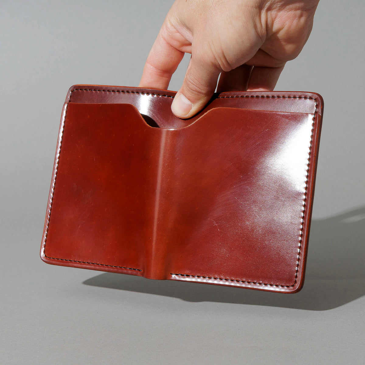 Fat Herbie in Garnet Shell Cordovan, Black Details, held open in hand, shot 2