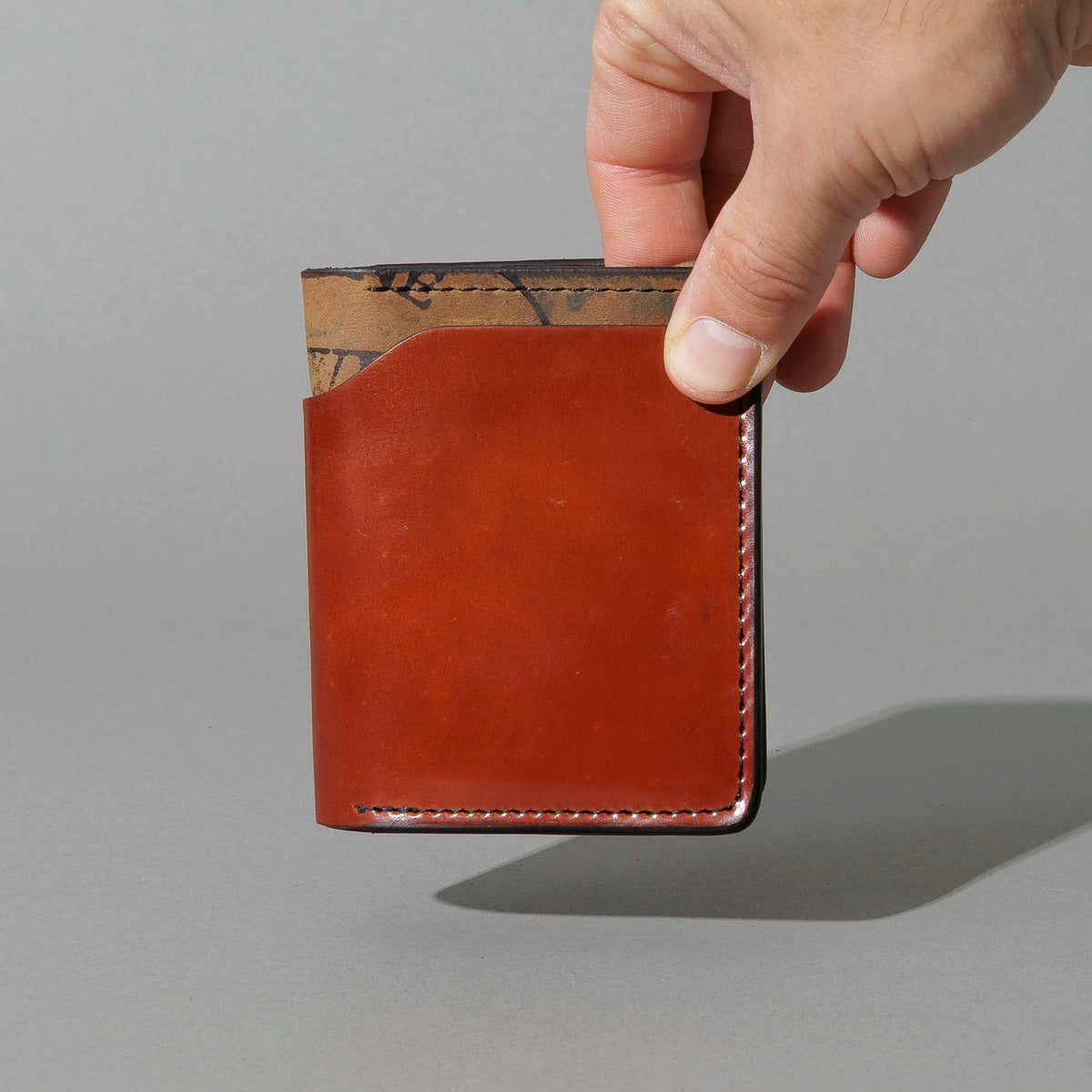 One-Off Vertical Tony the Ant in Blood Orange on Reverse Shell Cordovan, held in hand