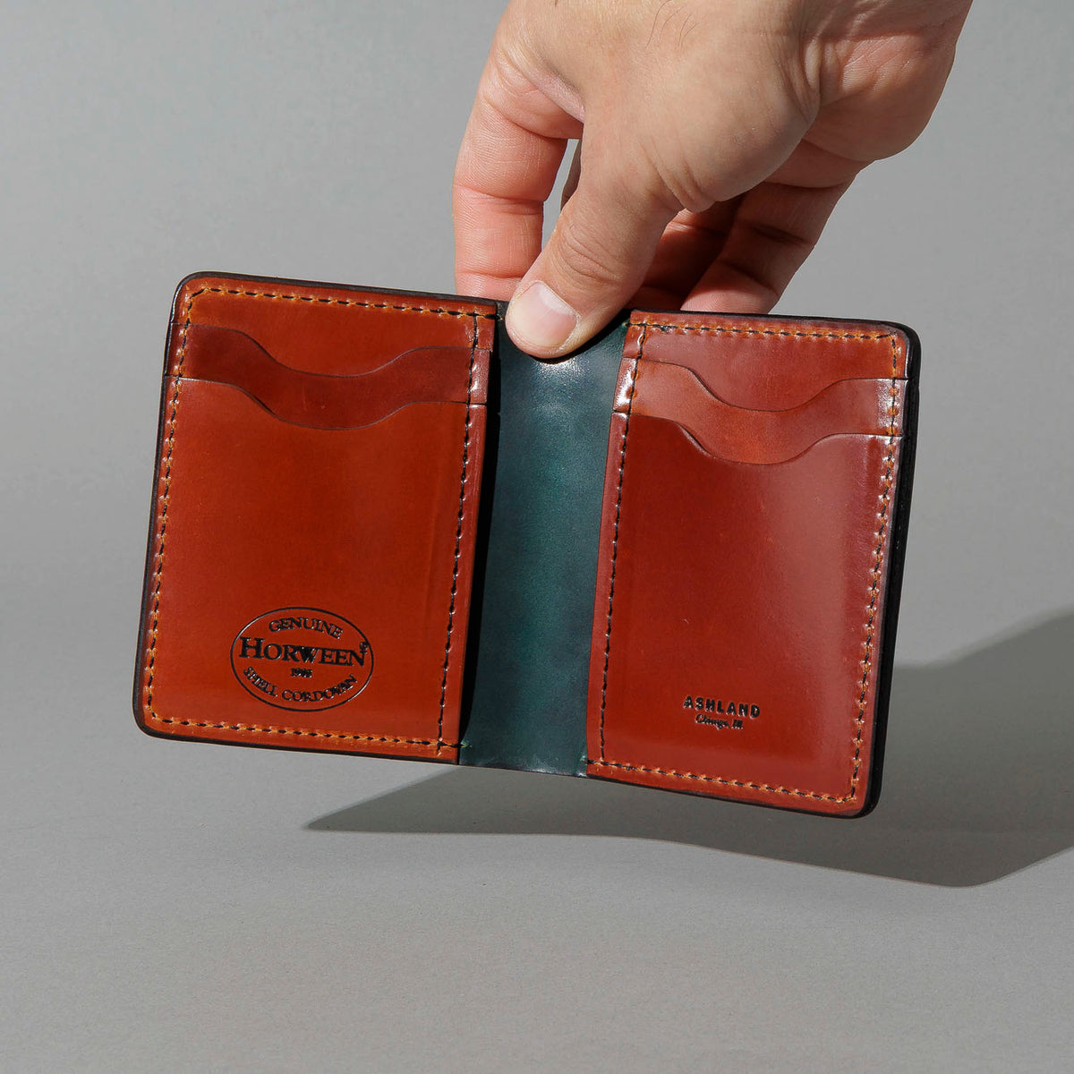 One-Off Vertical Tony the Ant in Blood Orange on Reverse Shell Cordovan, held open in hand, shot 1