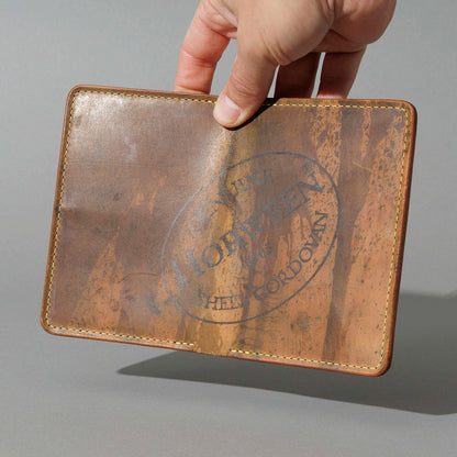 One-Off Traveler Passport Holder in Epic Splatter Reverse Cigar Shell Cordovan, No Bill Slot, held open in hand, shot 1