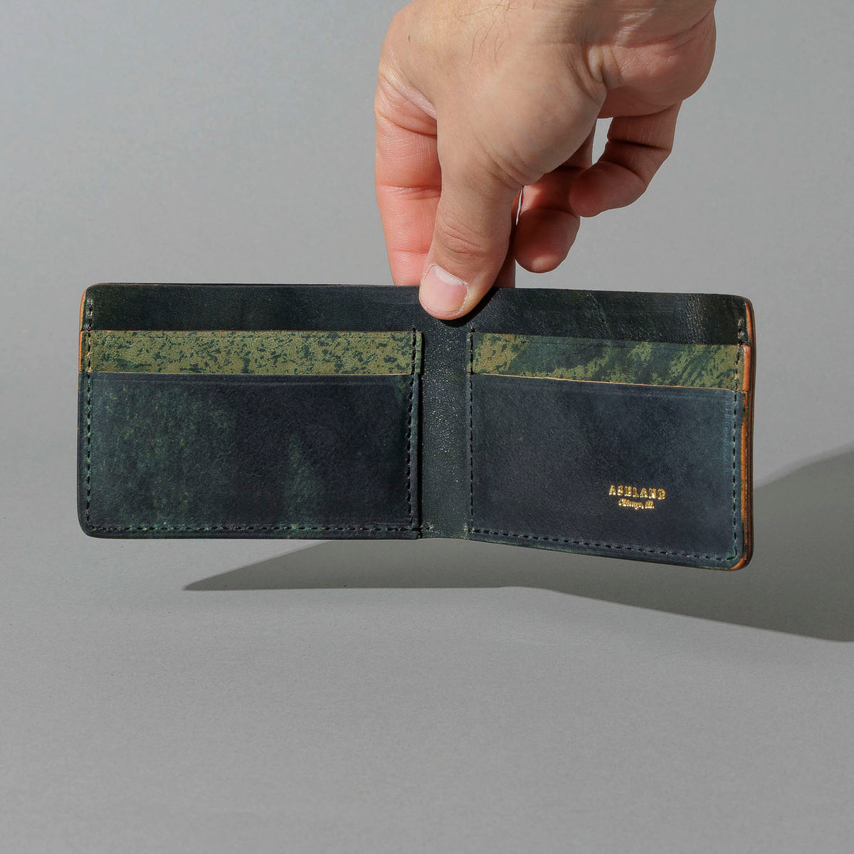 One-Off Nicky Slim in Hand-Glazed Epic Splatter Reverse Green Shell Cordovan, held open in hand, shot 2