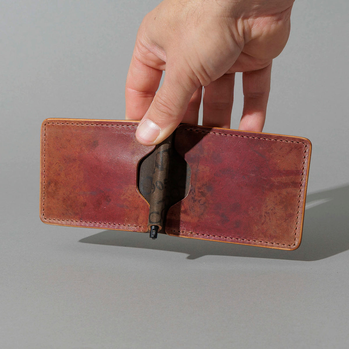 One-Off Capone Money Clip in Hand-Glazed Reverse Shell Cordovan, held open in hand, shot 1