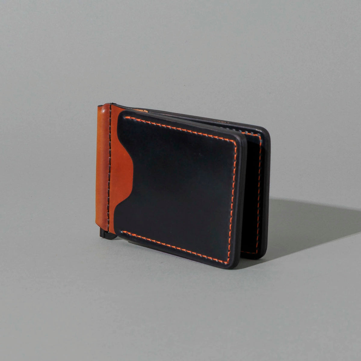 One-Off Capone Money Clip in Black on Blood Orange Shell Cordovan, standing upright, side angle
