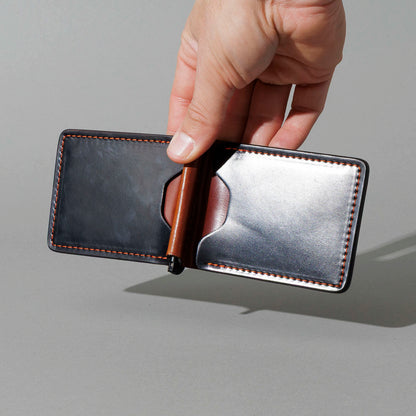 One-Off Capone Money Clip in Black on Blood Orange Shell Cordovan, held open in hand, shot 3