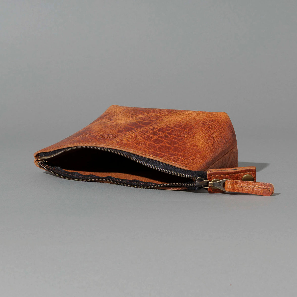 One-Off Prototype Pouch in Hammered Olive Tanned, angled view lying flat, shot 2