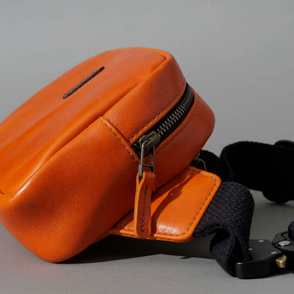 One-Off Sling Bag in Orange Latigo, angled view lying flat, shot 2