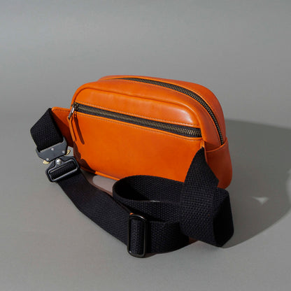 One-Off Sling Bag in Orange Latigo, angled view lying flat, shot 1