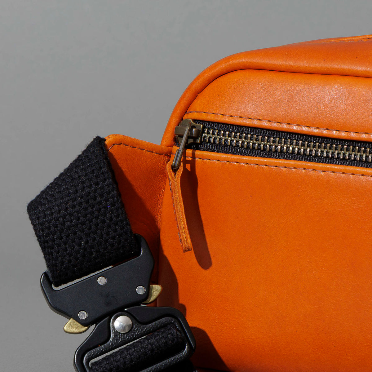 One-Off Sling Bag in Orange Latigo, close-up of the zipper, shot 1