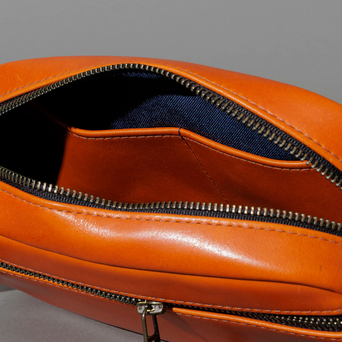 One-Off Sling Bag in Orange Latigo, unzipped, showing interior