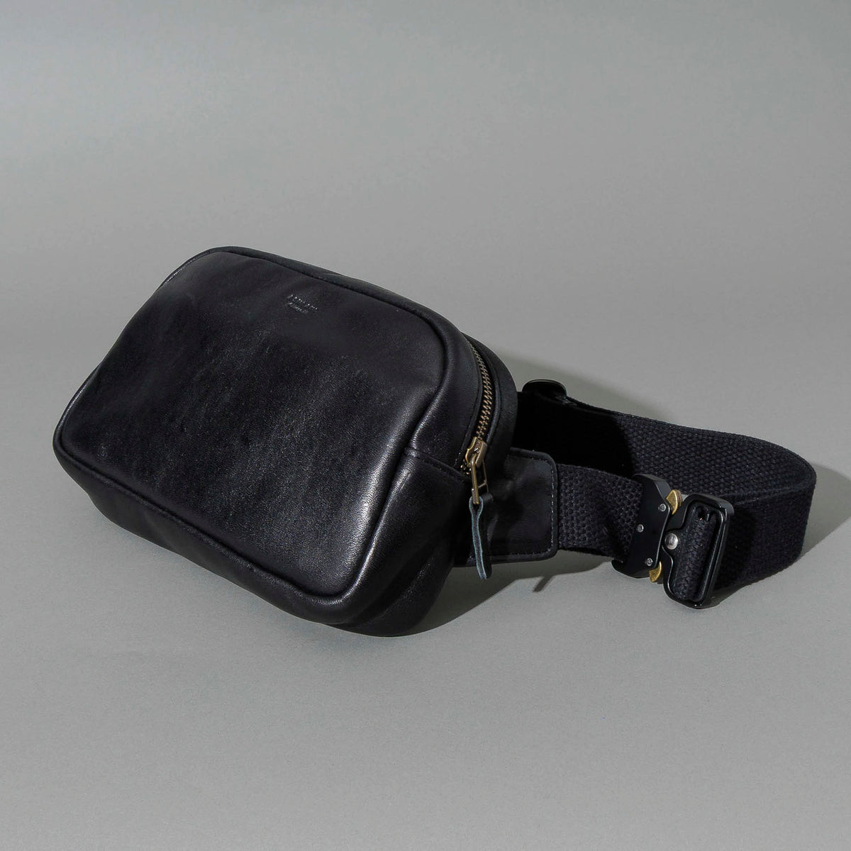 Sling Bag in Black Aspen Horsehide, angled view lying flat, shot 3