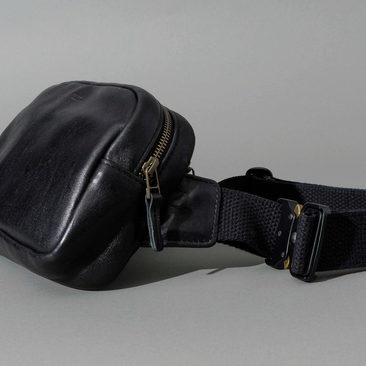 Sling Bag in Black Aspen Horsehide, angled view lying flat, shot 1