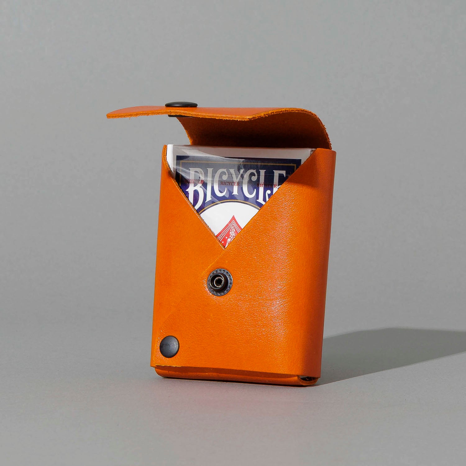Leather Playing Card Case in Orange Latigo, open with a deck of playing cards, shot 1