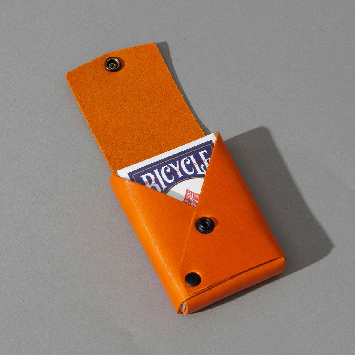 Leather Playing Card Case in Orange Latigo, open with a deck of playing cards, shot 3