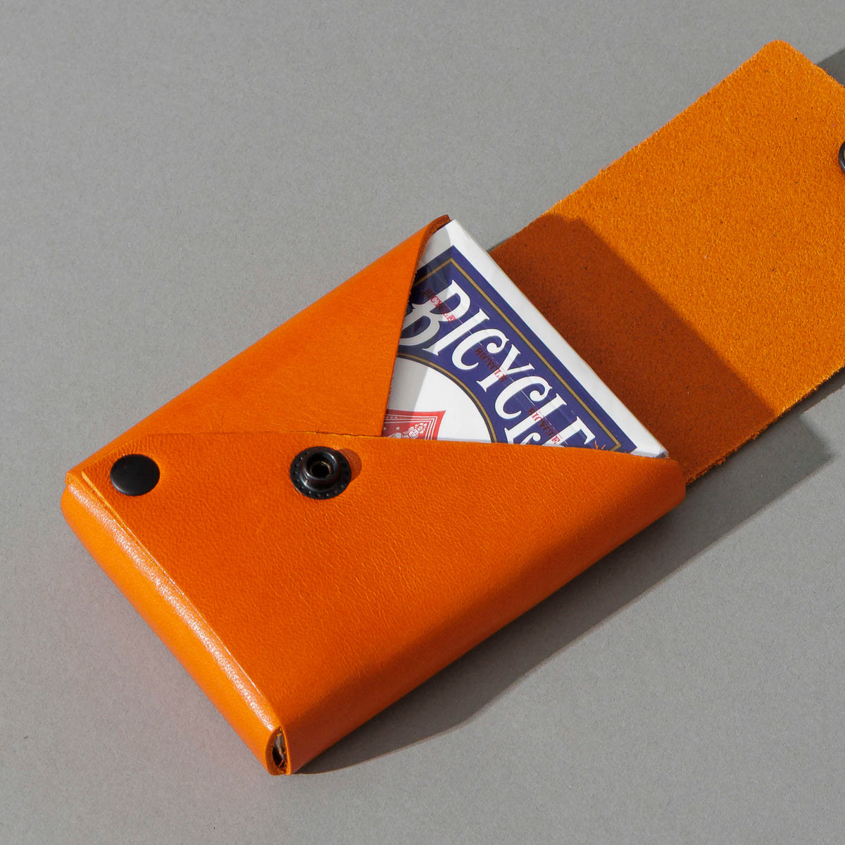 Leather Playing Card Case in Orange Latigo, open with a deck of playing cards, shot 2