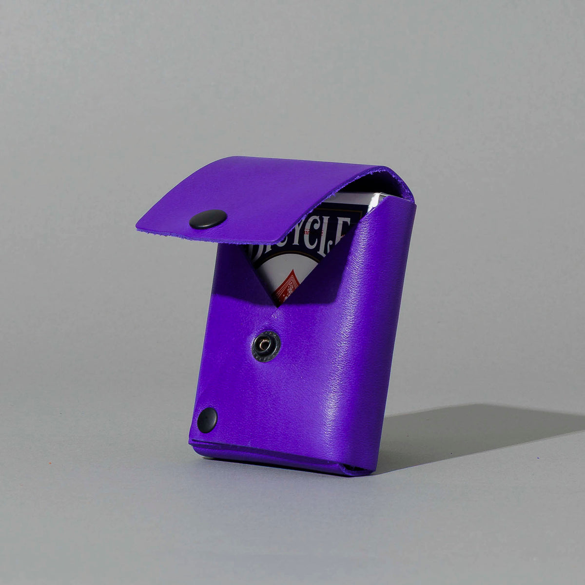 Leather Playing Card Case in Violet Latigo, open with a deck of playing cards, shot 1