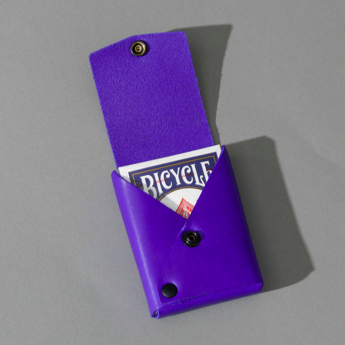 Leather Playing Card Case in Violet Latigo, open with a deck of playing cards, shot 2