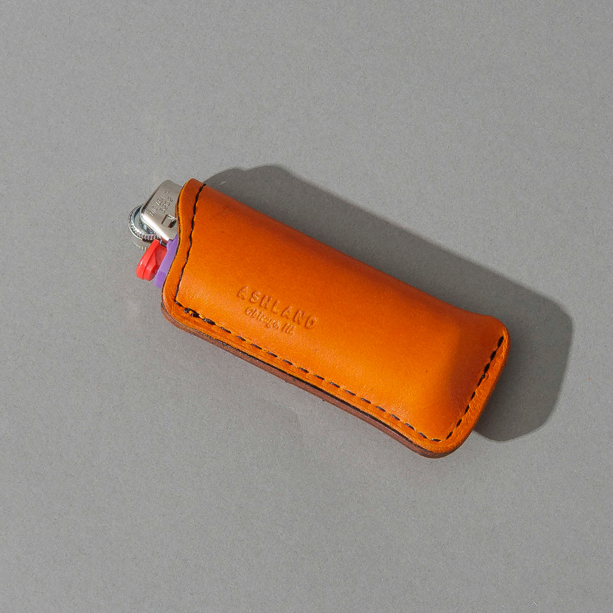 One-Off Skeleton Lighter in Orange Latigo, angled view lying flat