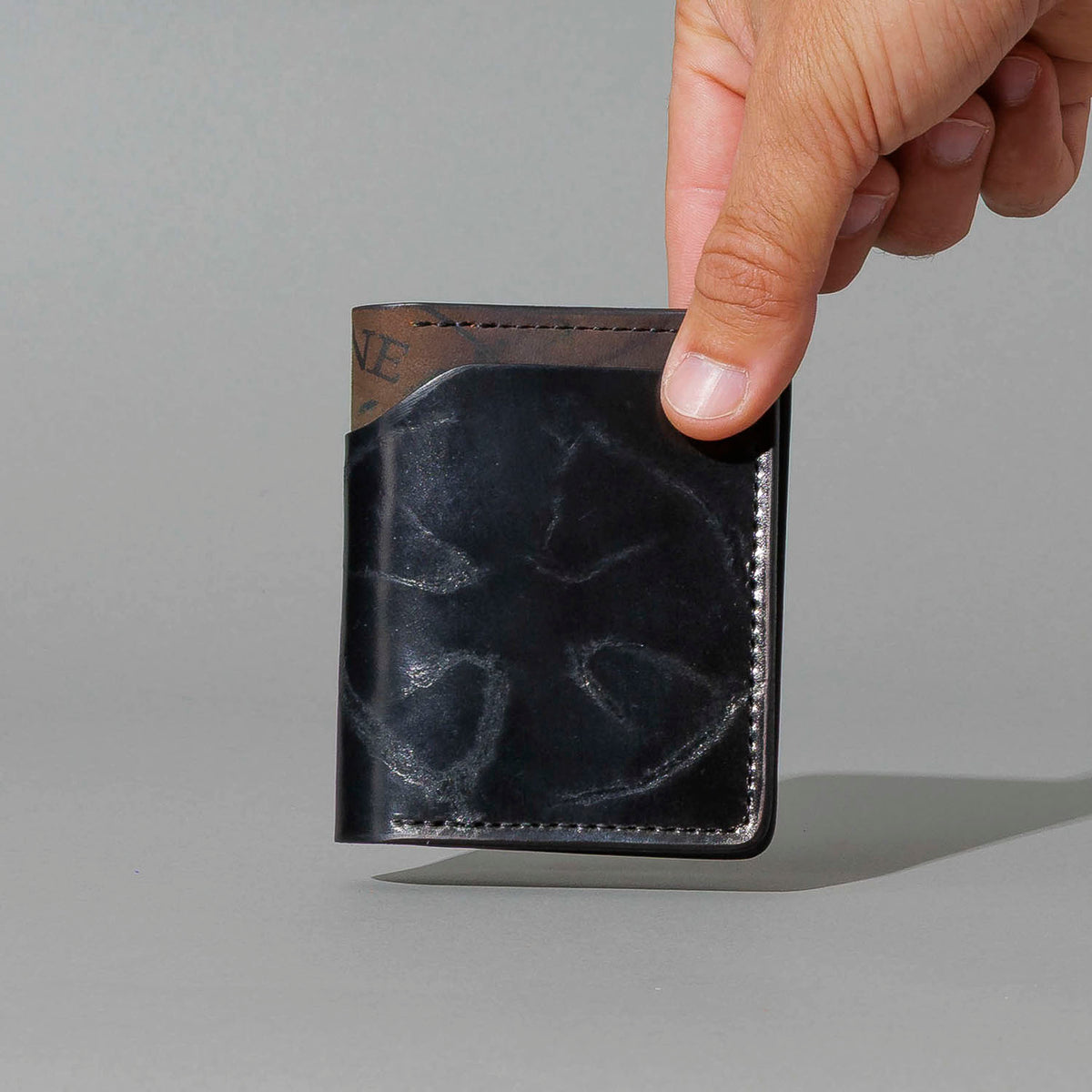 One-Off Tony the Ant in Branded Black and Reverse Shell Cordovan, Number Six Embroidery, held in hand, shot 1