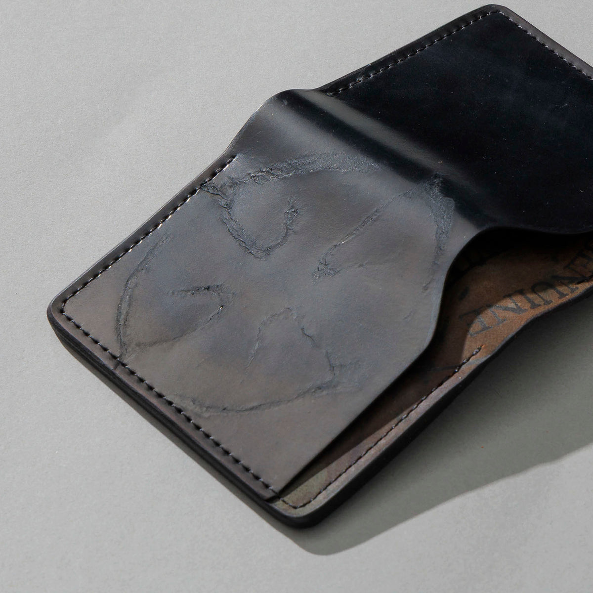 One-Off Tony the Ant in Branded Black and Reverse Shell Cordovan, Number Six Embroidery, angled view lying flat, shot 1