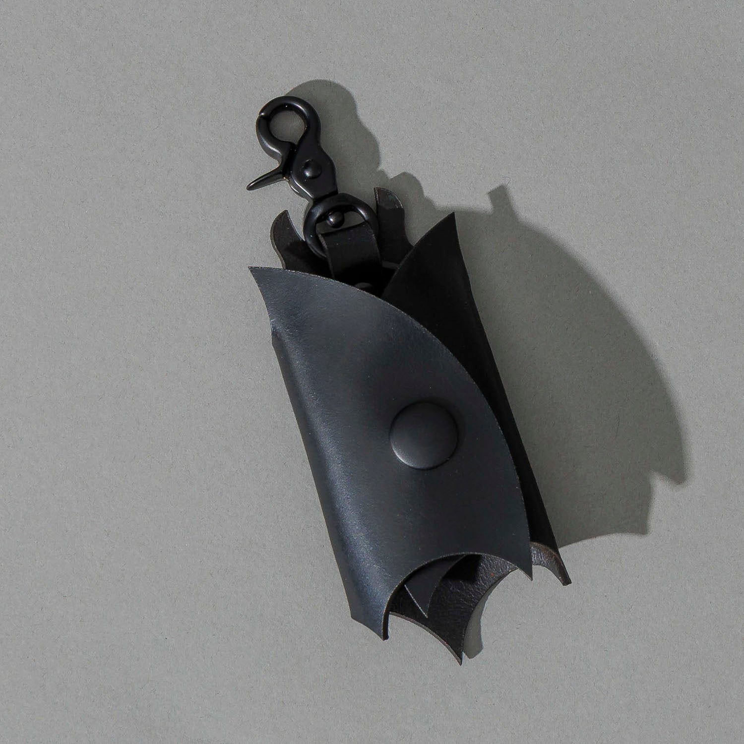 Bat Leather Key Case in Blacked Out Black Shell Cordovan, angled view lying flat