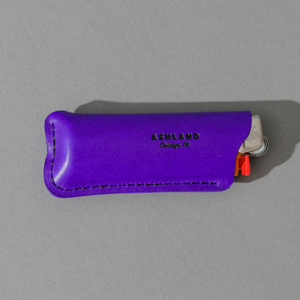 Lighter in Violet Latigo, angled view lying flat, shot 3