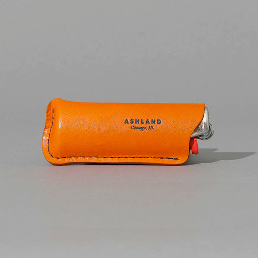 Lighter in Orange Latigo, angled view lying flat, shot 1